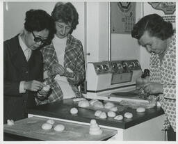 Three people in the Family Aide program working with dough