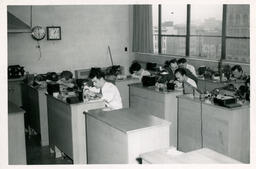 Students looking closely at items on desks
