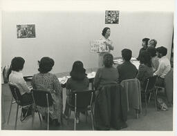 Instructor holding up a book to students