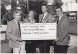 Four people hold a large cheque for VCC Educational Foundation