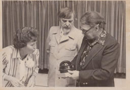 Three instructors looking at an object