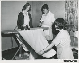 Three students in the Family Aide program ironing