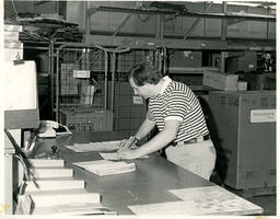 Person filling out forms in a warehouse