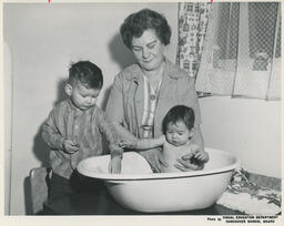 Student in Family Aide program holding baby in small tub