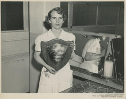 Student hold 1st place plaque for hairstyling competition, ca. 1954