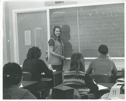 Instructor at a chalkboard with students watching