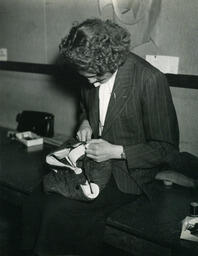 Tailoring student holding clothing item