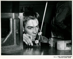 Student looking at mechanical device, ca. 1963