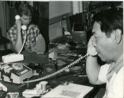 Two people talking on phones