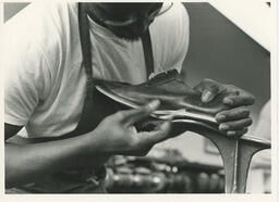 Close up of student holding a shoe on a shaper