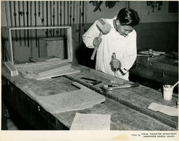 Student using a mallet on a workbench, ca. 1956