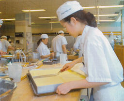 Baking student cutting