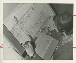 Student drawing a design at a drafting table