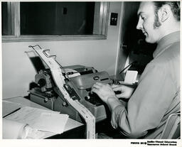 Person at typing machine, ca. 1972