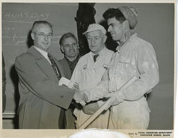 Plastering student shaking hands with administrator, ca. 1955