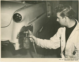 Student spray painting a car, ca. 1954