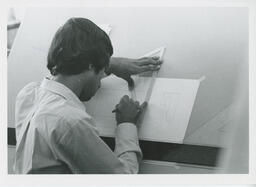 Student drawing a design at a drafting table