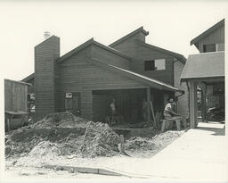 Students in front of a house under construction, ca. 1980