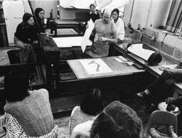 Lithography students watching instructor do screen printing