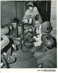 Instructor and students gathered around a machine, ca. 1972