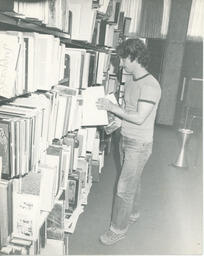 Student in front of library stack