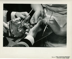 Close up of hands with dental tools, ca. 1964