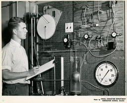 Student at wall of equipment, ca. 1963