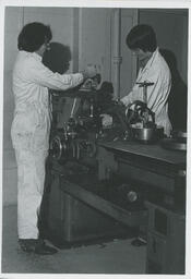 Two students work on machines