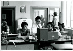 Instructor and two students looking at electronic machine
