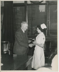 Graduating nurse shakes hands with administrator