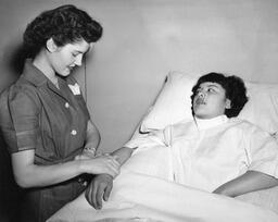 Nursing student attending to patient, ca. 1950