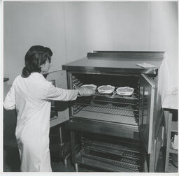 Student takes food out of oven